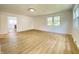 Bright living room with light wood floors, white walls, and natural light from the large window at 453 Illinois St, Fortville, IN 46040