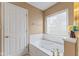 Bright bathroom featuring a soaking tub with jets, and large window at 4907 Franklin Villas Pl, Indianapolis, IN 46237