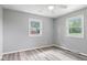 A neutral bedroom is illuminated by two windows, showcasing a serene and bright space at 522 E County Road 1000 S, Clayton, IN 46118