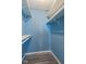 Empty blue walk-in closet with gray wood floors, white shelves, and base molding at 522 E County Road 1000 S, Clayton, IN 46118