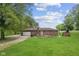 Exterior view of the back of a one-story brick home with a big backyard at 522 E County Road 1000 S, Clayton, IN 46118