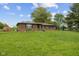 Brick house with a large lawn and mature trees under a blue sky at 522 E County Road 1000 S, Clayton, IN 46118