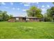 Lovely brick home with green lawn, blooming flowers, and mature trees at 522 E County Road 1000 S, Clayton, IN 46118