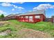Spacious backyard featuring a red deck, lush green grass, and a brick home exterior at 5305 Adrian Orchard Dr, Indianapolis, IN 46217