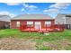 View of the home's backyard with a red wooden deck and a brick house exterior at 5305 Adrian Orchard Dr, Indianapolis, IN 46217