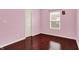 This bedroom has a light pink color scheme, natural light, and beautiful hardwood floors at 5305 Adrian Orchard Dr, Indianapolis, IN 46217