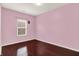 This bedroom has a light pink color scheme, natural light, and beautiful hardwood floors at 5305 Adrian Orchard Dr, Indianapolis, IN 46217