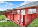 This is a red painted deck attached to a brick house with a grassy yard at 5305 Adrian Orchard Dr, Indianapolis, IN 46217