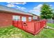 This is a red painted deck that is attached to a brick house and has a green yard at 5305 Adrian Orchard Dr, Indianapolis, IN 46217