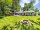 Large backyard with lush lawn, mature trees, and inviting fire pit at 616 W Michigan St, Greenfield, IN 46140