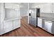 Well-lit kitchen with stainless steel refrigerator, dishwasher, and white cabinets at 616 W Michigan St, Greenfield, IN 46140