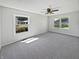 An empty bedroom showing neutral colors, two windows, ceiling fan, and carpet flooring at 616 W Michigan St, Greenfield, IN 46140