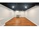 Spacious finished basement featuring wood-look flooring and painted ceilings at 6176 Kingsley Dr, Indianapolis, IN 46220