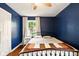 Bedroom with white walls, hardwood floors, and a decorative iron bed frame at 6176 Kingsley Dr, Indianapolis, IN 46220