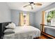 Comfortable bedroom with natural light, featuring hardwood floors and a ceiling fan at 6176 Kingsley Dr, Indianapolis, IN 46220