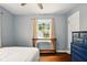 Bright bedroom with blue accent wall, featuring hardwood floors and natural light at 6176 Kingsley Dr, Indianapolis, IN 46220