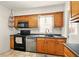 Well-lit kitchen features wooden cabinets, tile floors, and a stainless-steel dishwasher at 6176 Kingsley Dr, Indianapolis, IN 46220