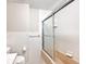 Bright bathroom showcasing white tiles, a toilet, and a shower/tub combo with sliding glass doors at 6248 Graham Rd, Indianapolis, IN 46220