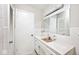 Well-lit bathroom featuring white tile, a single sink vanity, and a mirrored medicine cabinet at 6248 Graham Rd, Indianapolis, IN 46220