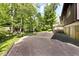 Side view of driveway with mature trees and basketball hoop surrounded by trees on a sprawling lot, perfect for Gathering activities at 6248 Graham Rd, Indianapolis, IN 46220