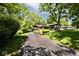 Charming home surrounded by mature trees and greenery, showcasing a well-manicured front yard and long driveway at 6248 Graham Rd, Indianapolis, IN 46220