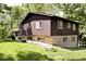 Home featuring stone accents and wood siding, complemented by well-maintained landscaping and natural light at 6248 Graham Rd, Indianapolis, IN 46220