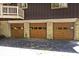 Three-car garage with wood doors and stone accents offering ample parking and storage space for all your vehicles and extras at 6248 Graham Rd, Indianapolis, IN 46220