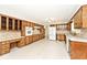 Spacious kitchen with wood cabinets, stone backsplash, and white appliances at 6248 Graham Rd, Indianapolis, IN 46220