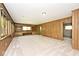 Large living room featuring built-in bookcases, wood-panelled walls, and large windows at 6248 Graham Rd, Indianapolis, IN 46220