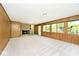 Spacious living room with stone fireplace, wood-panelled walls, and a wall of windows at 6248 Graham Rd, Indianapolis, IN 46220