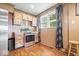 Country kitchen featuring stainless appliances, wood floors and decorative curtains at 671 W 350 N, Shelbyville, IN 46176