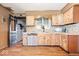 Well-lit kitchen with stainless steel appliances, wood floors and stone backsplash at 671 W 350 N, Shelbyville, IN 46176