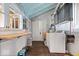 Bright laundry room features a washer and dryer, storage cabinets, wooden floors, and ample natural light from the large window at 671 W 350 N, Shelbyville, IN 46176