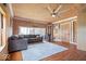 Comfortable living room showcasing hardwood floors, wood paneled ceilings, a gray sectional, and natural light at 671 W 350 N, Shelbyville, IN 46176