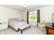 Bright bedroom featuring a comfortable bed, chair, and window with views of lush greenery at 6832 Oakcrest Dr, McCordsville, IN 46055