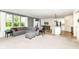 Open-concept living room with a large window, grey sectional sofa, and bright, neutral carpet at 6832 Oakcrest Dr, McCordsville, IN 46055