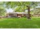 Large backyard with lush grass and a brick house at 7135 Huntington Rd, Indianapolis, IN 46240