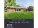 Charming one-story red brick home with a well-manicured lawn and covered front porch at 7135 Huntington Rd, Indianapolis, IN 46240