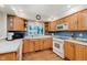 Functional kitchen featuring ample wood cabinetry and white appliances at 7135 Huntington Rd, Indianapolis, IN 46240