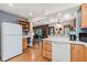 Traditional eat-in kitchen with wood cabinets, modern appliances, hardwood floors, and views of living spaces at 7135 Huntington Rd, Indianapolis, IN 46240