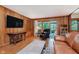 Comfortable living room offering wood walls, access to porch, and wood floors at 7135 Huntington Rd, Indianapolis, IN 46240