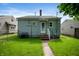 Rear exterior view of a cozy home with green lawn, showcasing its simple charm at 732 S Biltmore Ave, Indianapolis, IN 46241