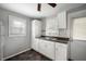A functional kitchen with white cabinets, neutral walls, a sink with an adjacent door to the backyard at 732 S Biltmore Ave, Indianapolis, IN 46241