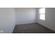 A simple carpeted bedroom is brightened by a clear window at 7329 Waylon Way, Indianapolis, IN 46239