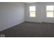 Bright bedroom with two windows offering pleasant outdoor views and neutral carpeting at 7329 Waylon Way, Indianapolis, IN 46239