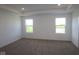 Bright main bedroom with plush carpet, recessed lighting, and large windows overlooking the yard at 7329 Waylon Way, Indianapolis, IN 46239