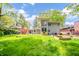 Large backyard with lush grass, garden beds, and mature trees, great for outdoor activities at 806 Maplewood Ave, Anderson, IN 46012