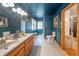 Stylish bathroom with double sinks, wood cabinets, tile floor, and blue walls at 806 Maplewood Ave, Anderson, IN 46012
