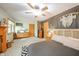 Light-filled bedroom with neutral carpet, ceiling fan, decor, and a woven headboard at 806 Maplewood Ave, Anderson, IN 46012
