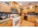 Updated kitchen features wood cabinets, granite counters, and modern white appliances at 806 Maplewood Ave, Anderson, IN 46012